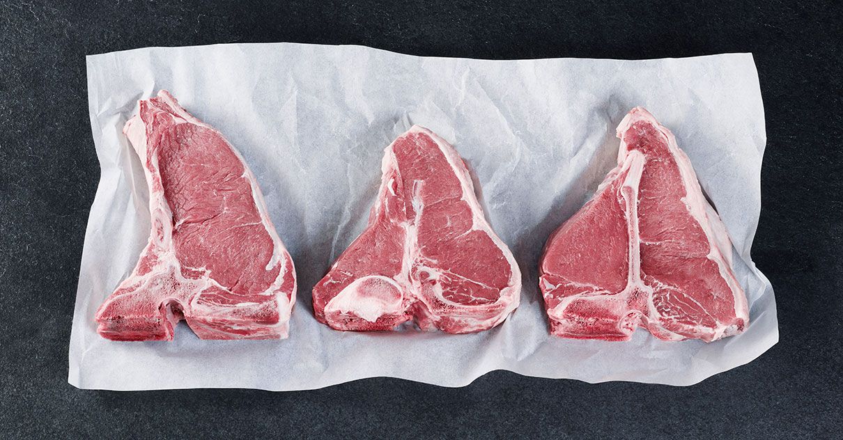 3 Steaks vom Kalbsrücken liegen auf einem Papier